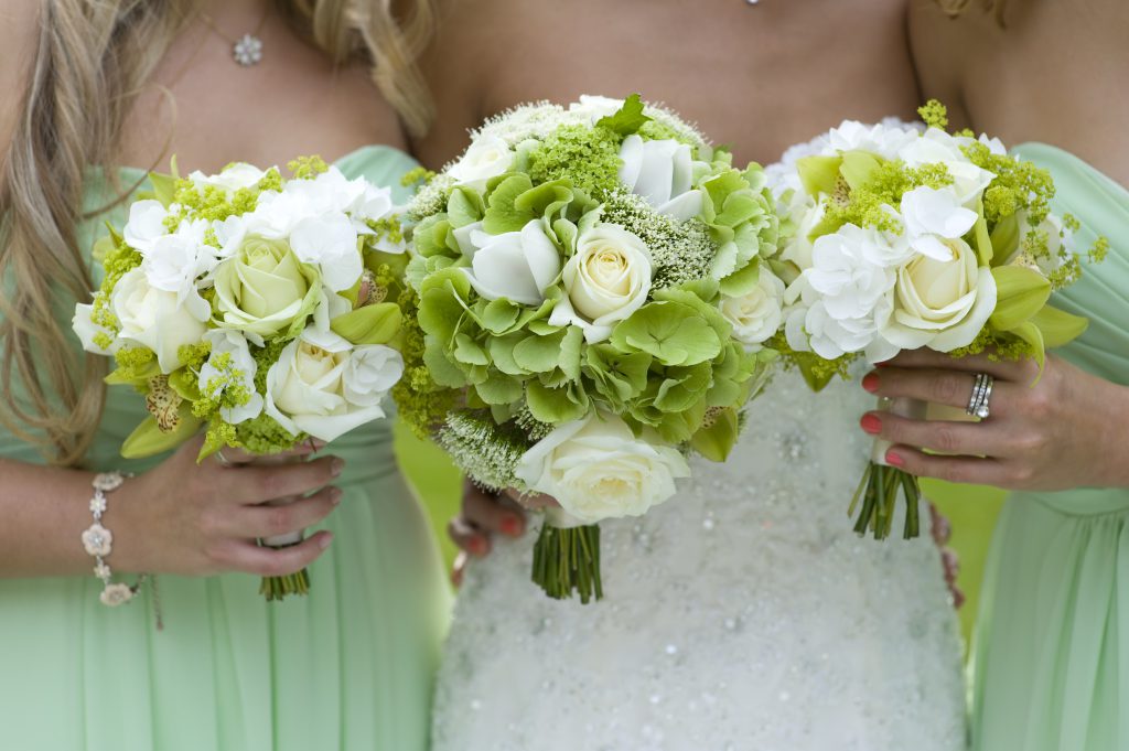 bridesmaids in green with wedding bouquet